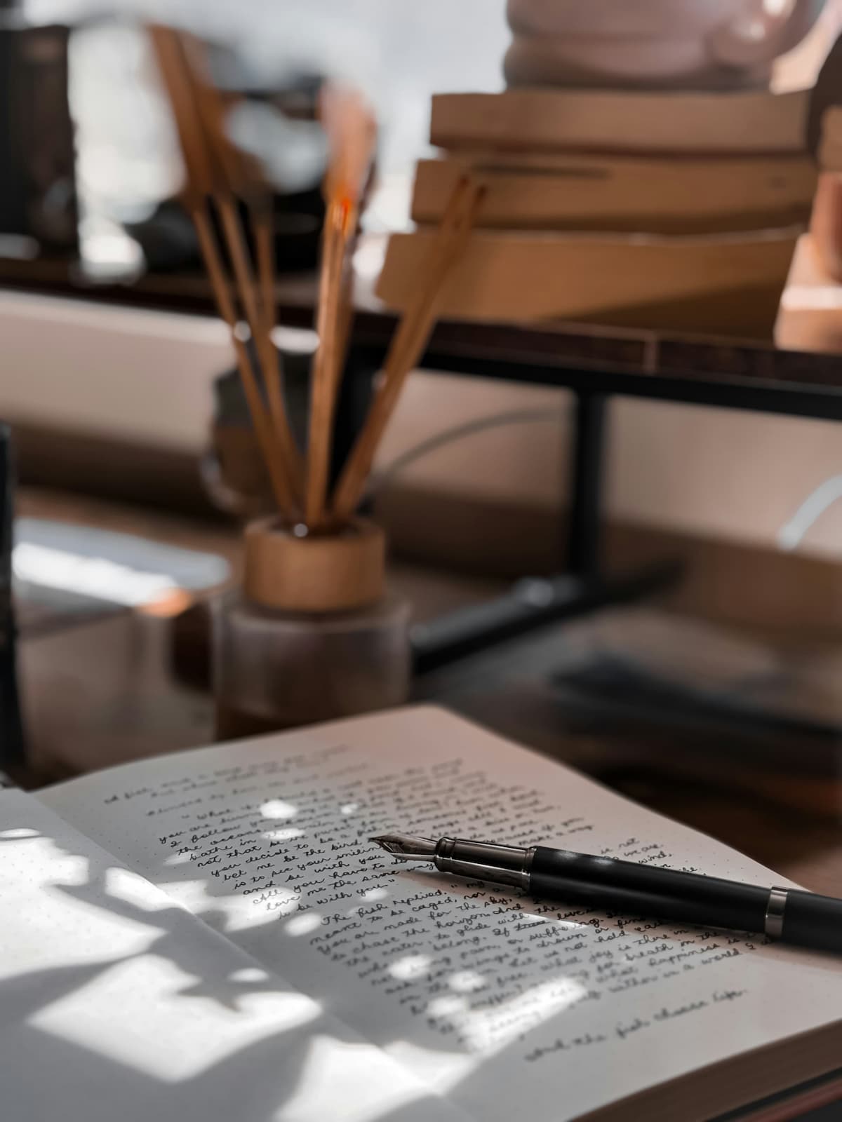 An open journal with a handwritten page in sunlight, beside a fountain pen